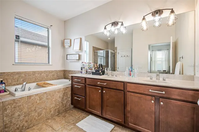a spacious bathroom with a tub sink and mirror