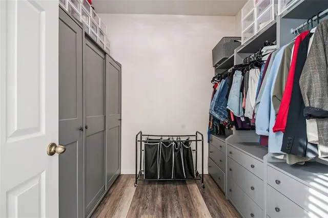 a view of walk in closet with clothes and shoes