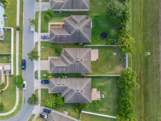 an aerial view of a house with garden space and a lake view