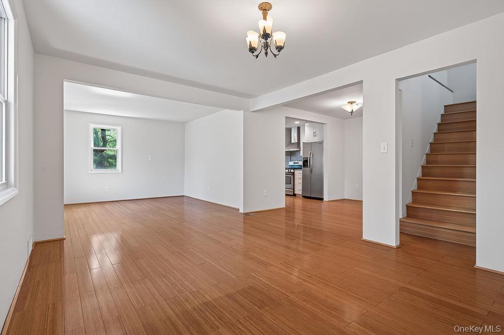 6 Winterberry Road Fishkill, NY 12524 - Photo 7 of 43 Spacious interior featuring wood-finish bamboo flooring throughout, a visible kitchen area with stainless steel appliances, and a staircase with wood treads