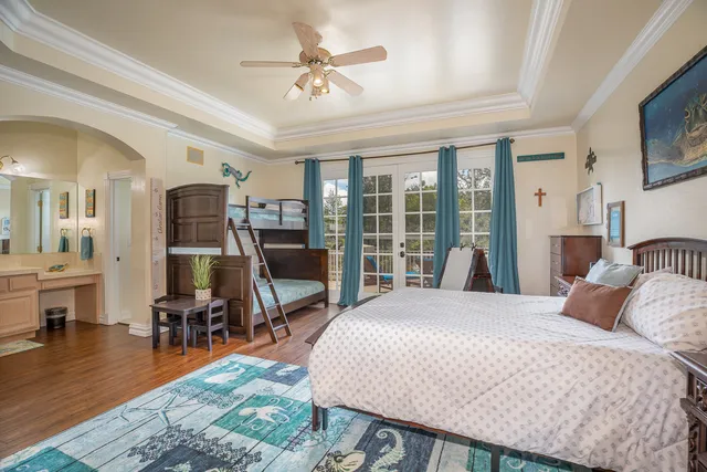 a bedroom with a bed a chandelier and flat screen tv