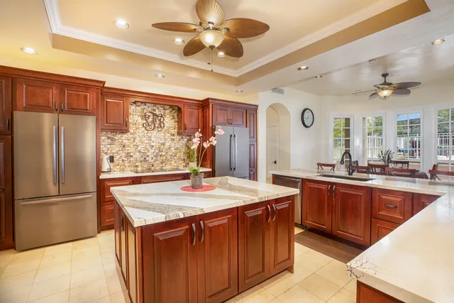 a kitchen with stainless steel appliances granite countertop a sink a stove and a refrigerator