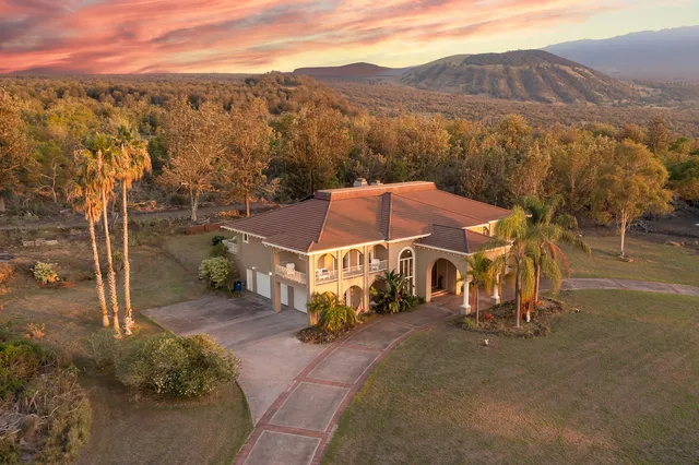 an aerial view of a house with a big yard