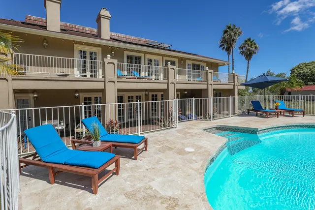 a view of a house with a swimming pool and sitting area