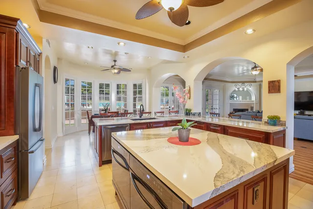 a room with stainless steel appliances kitchen island granite countertop a sink and cabinets
