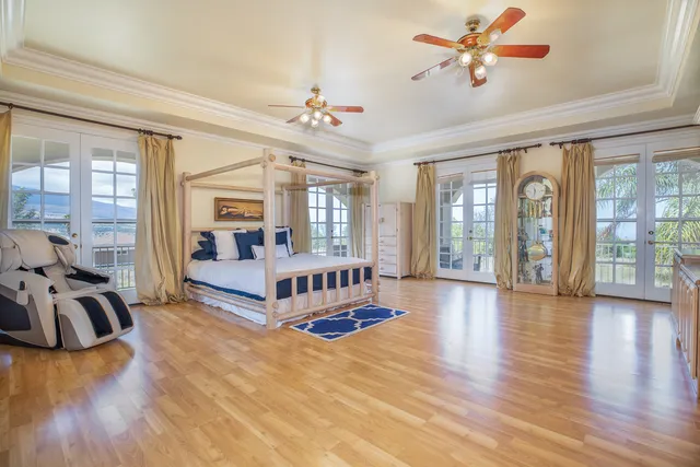 a spacious bedroom with a balcony a bed and a chandelier