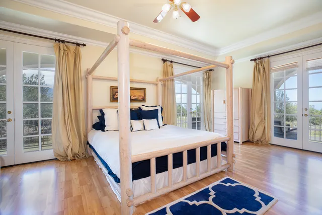 a large bedroom with a bed and wooden floor