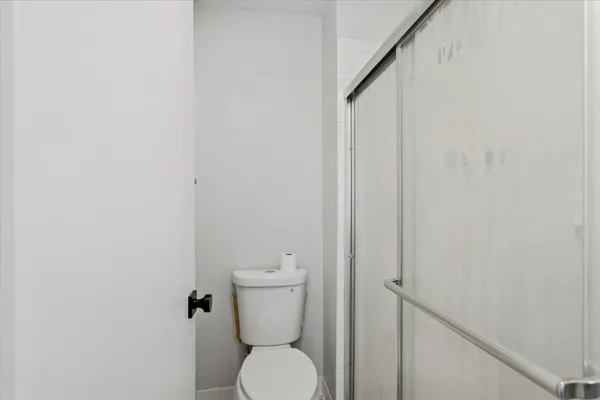 a white toilet sitting next to a white wall