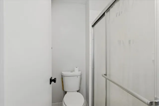 a white toilet sitting next to a white wall
