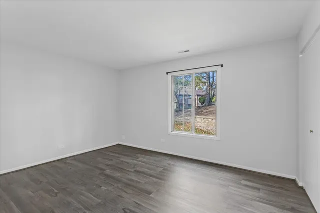 an empty room with wooden floor and window