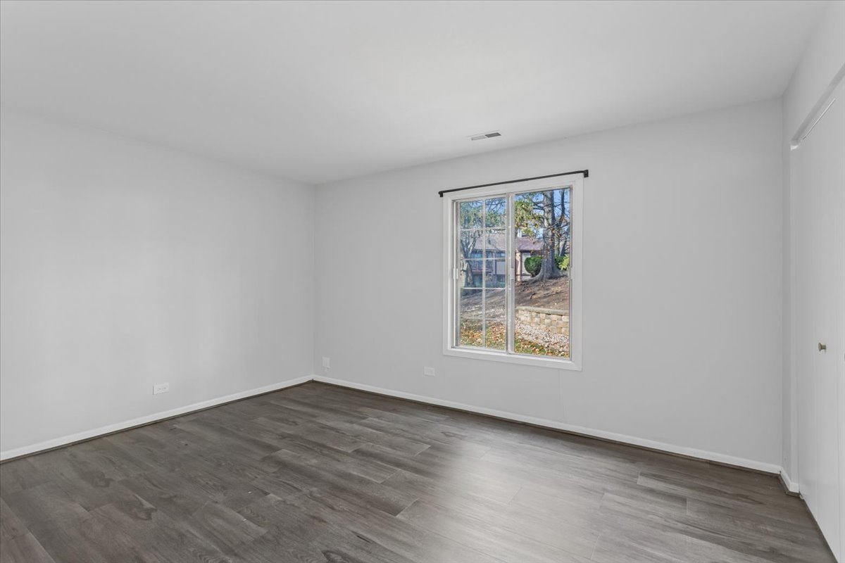 1601 Thames Court, Unit A Wheaton, IL 60189 - Photo 14 of 21 an empty room with wooden floor and window