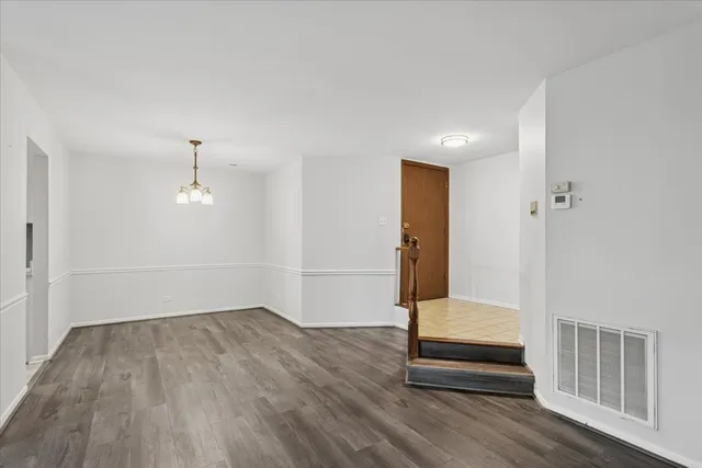 an empty room with wooden floor and bathroom