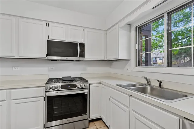 a kitchen with stainless steel appliances a stove a microwave a sink and cabinets
