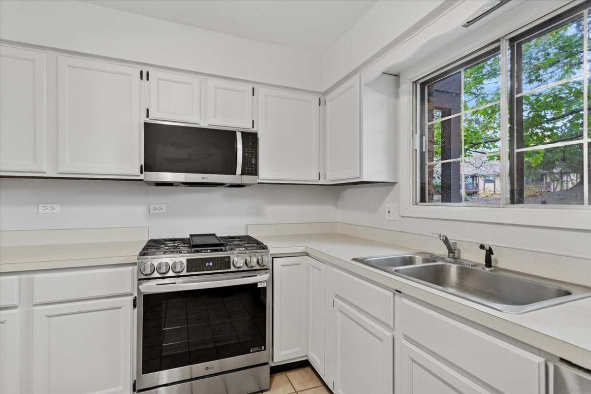 1601 Thames Court, Unit A Wheaton, IL 60189 - Photo 9 of 21 a kitchen with stainless steel appliances a stove a microwave a sink and cabinets