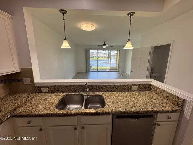 a kitchen with a sink a counter space and a granite counter tops