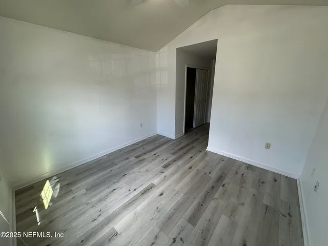 a view of an empty room with wooden floor