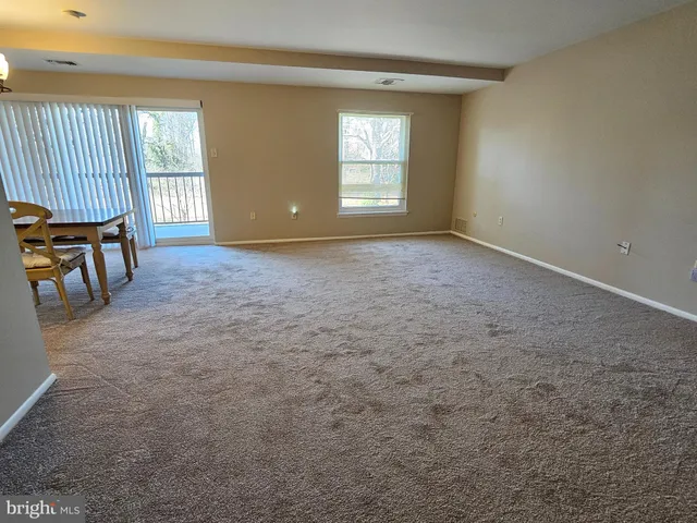 an empty room with a fireplace and windows