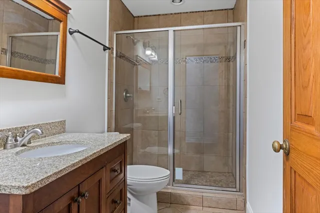 a bathroom with a granite countertop sink toilet and shower