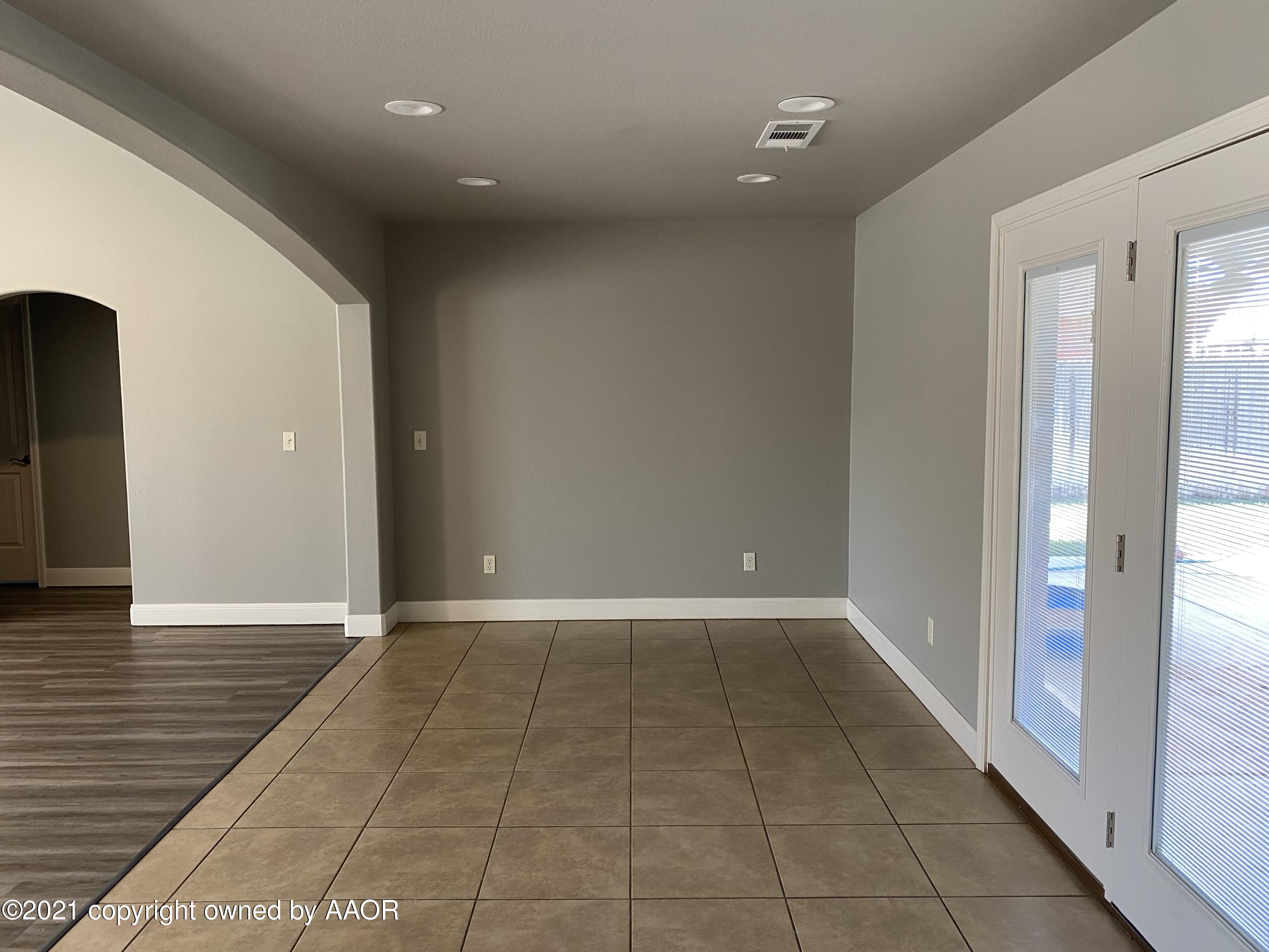 7304 Jacksonhole Drive Amarillo, TX 79118 - Photo 4 of 14 an empty room with wooden floor and windows