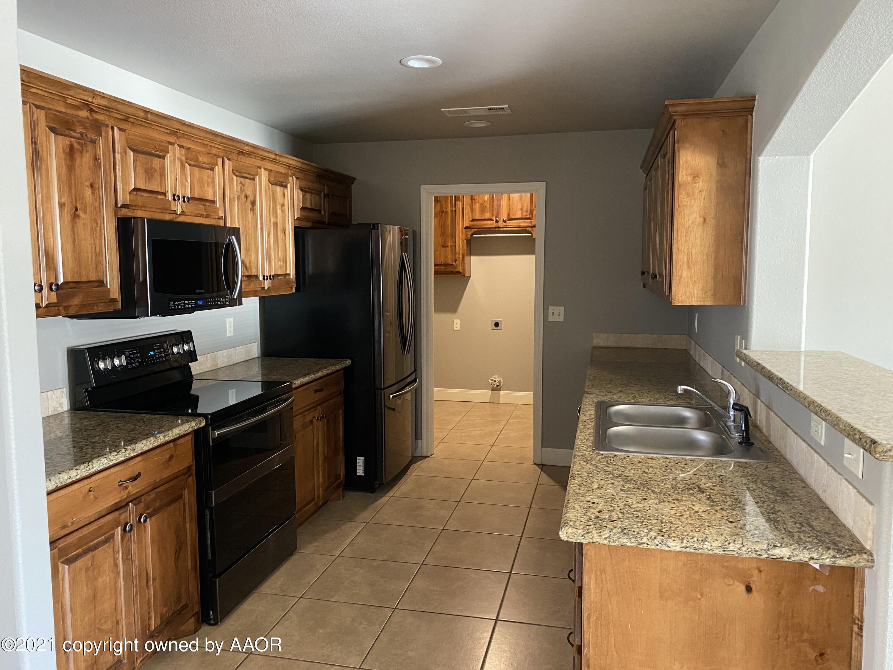 7304 Jacksonhole Drive Amarillo, TX 79118 - Photo 5 of 14 a kitchen with a sink stove and refrigerator