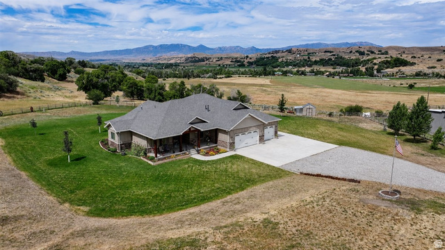 3123 East Riverdale Road Preston, ID 83263 - Photo 43 of 52 Spacious ranch-style residence featuring a covered front porch, an attached three-car garage, a concrete driveway, and a gravel driveway