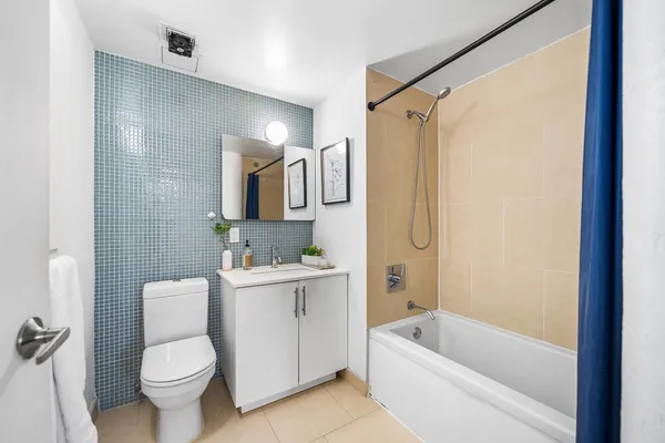 a bathroom with a sink a toilet a mirror a vanity and bathtub