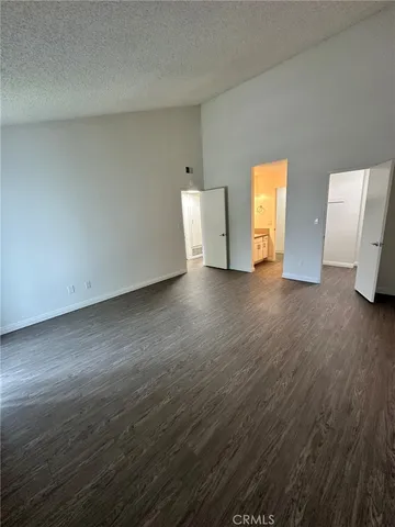 a view of empty room with wooden floor and window
