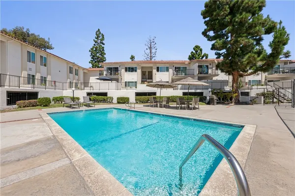a swimming pool view with a seating space and a garden