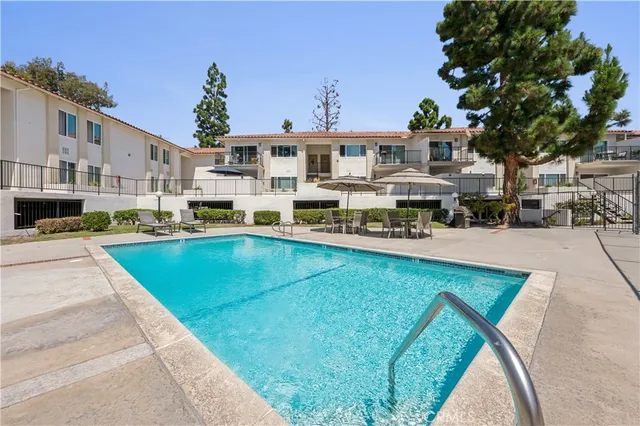 a swimming pool view with a seating space and a garden