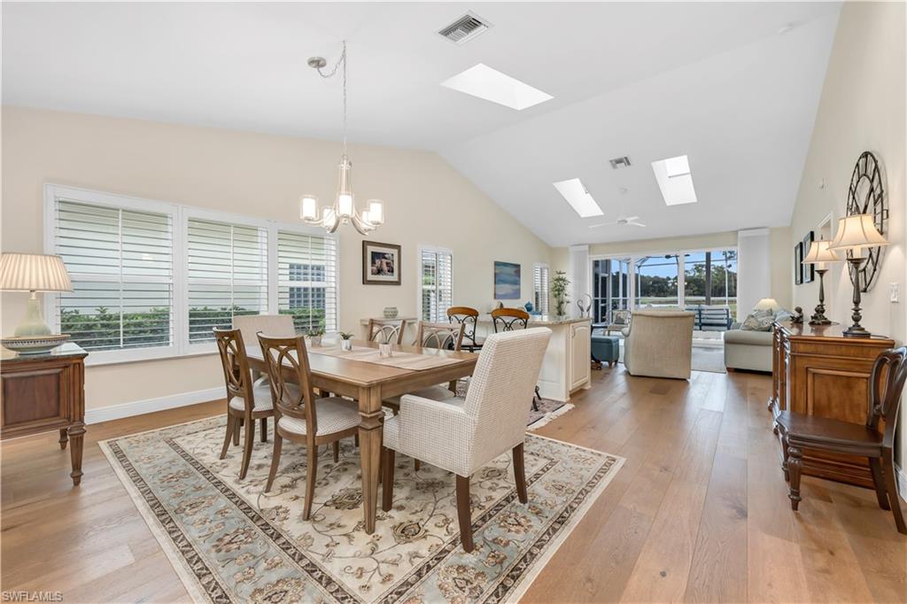 224 Edgemere Way South Naples, FL 34105 - Photo 5 of 35 Dining space featuring a skylight, light wood finished floors, a chandelier, and high vaulted ceiling