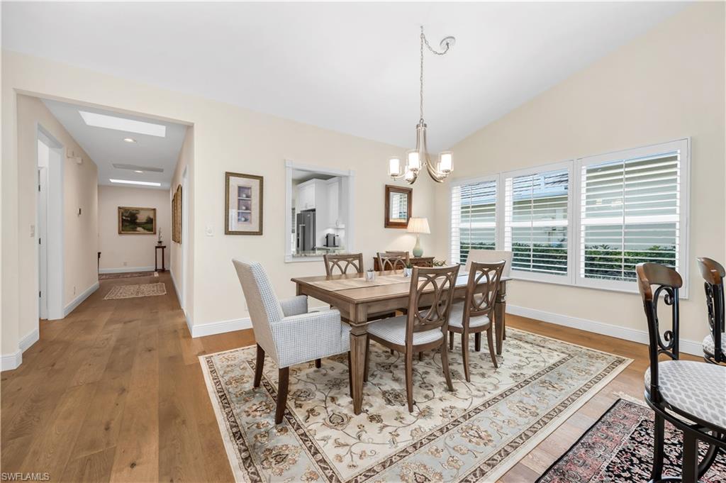 224 Edgemere Way South Naples, FL 34105 - Photo 6 of 35 Dining area featuring light wood-type flooring, a chandelier, and lofted ceiling