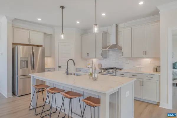 a kitchen with stainless steel appliances granite countertop a sink a stove a refrigerator and island with wooden floor