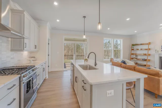 a kitchen with stainless steel appliances granite countertop a sink a stove and a wooden floors