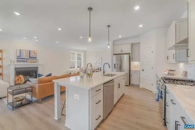 a large kitchen with stainless steel appliances a stove a sink a oven and a refrigerator