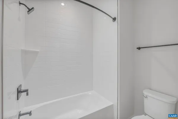 a white bath tub sitting next to a white toilet and a shower