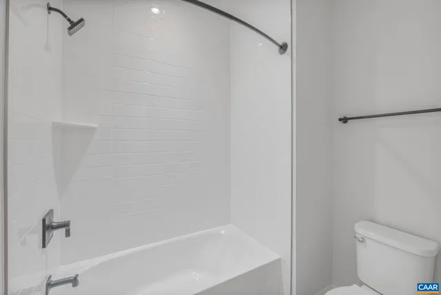 a white bath tub sitting next to a white toilet and a shower