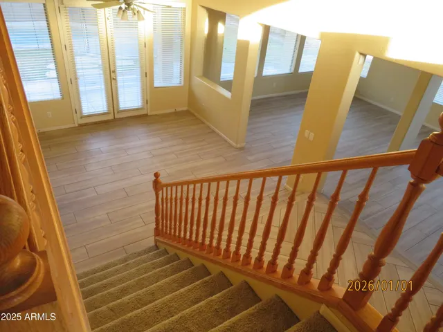 a view of a backyard with table and chairs potted plants and large tree