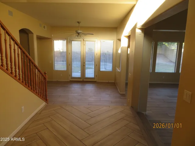 a view of hallway with a large window and wooden floor