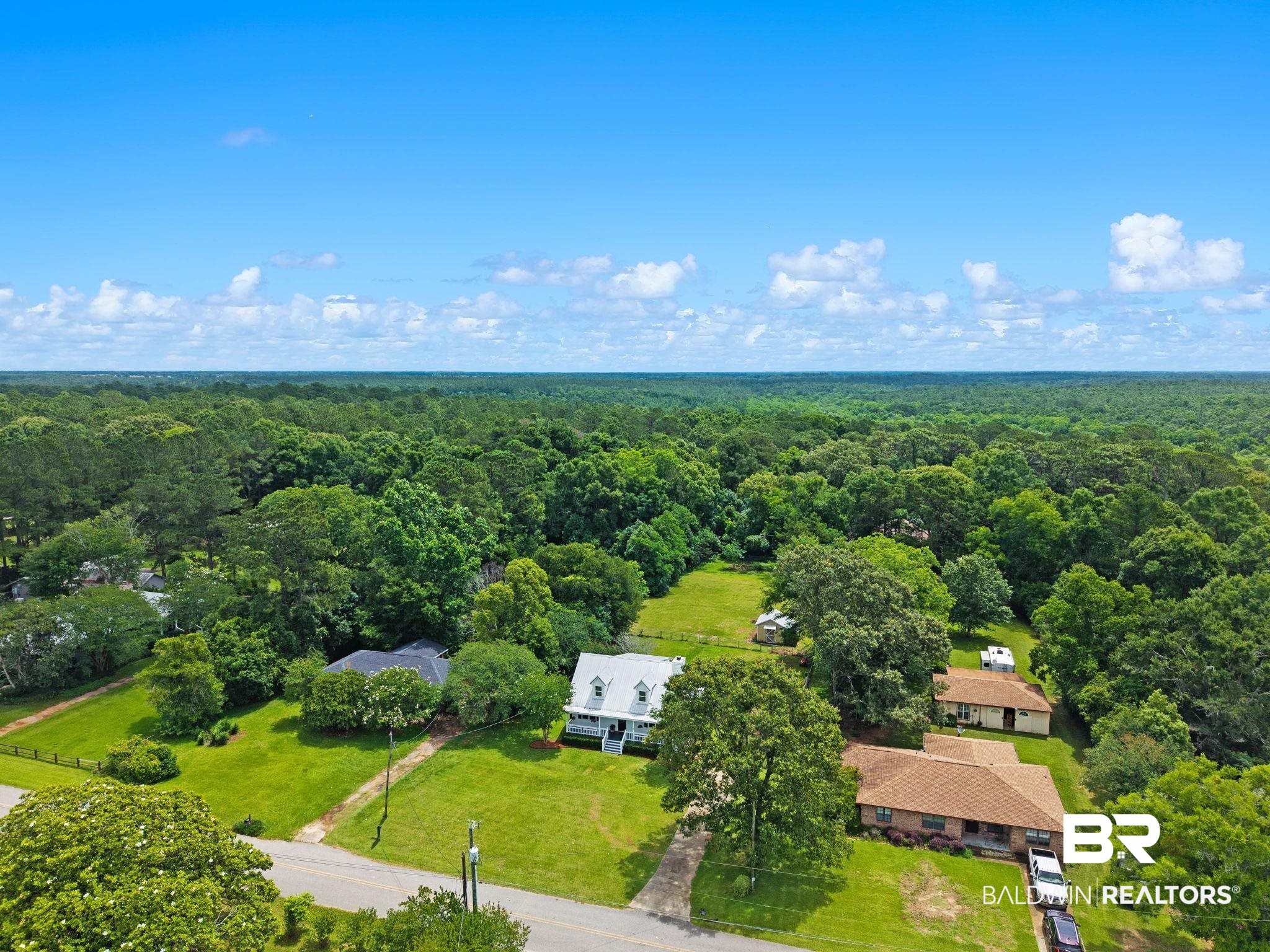 22810 High Ridge Road Fairhope, AL 36532 - Photo 64 of 78 Expansive wooded surroundings provide a natural setting for this property, featuring a white exterior with a gray roof and dormer windows