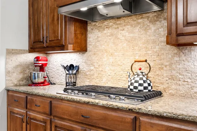 a kitchen with stainless steel appliances granite countertop a sink dishwasher stove and refrigerator with wooden floor