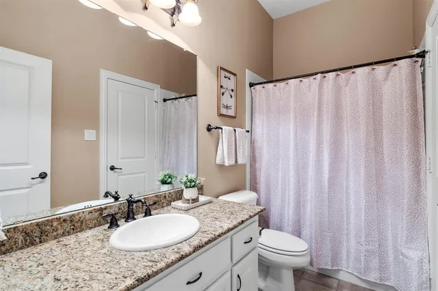a bathroom with a toilet a sink and a mirror