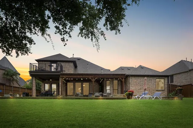a view of a big house with a big yard and large trees