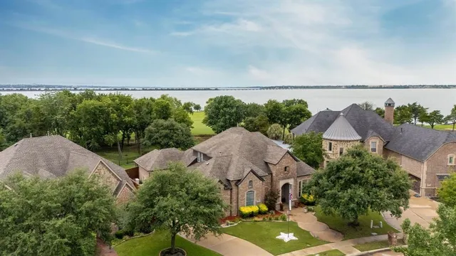 an aerial view of a house with a yard and lake view