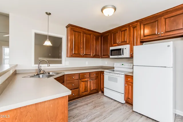a kitchen with stainless steel appliances granite countertop a sink stove microwave and refrigerator