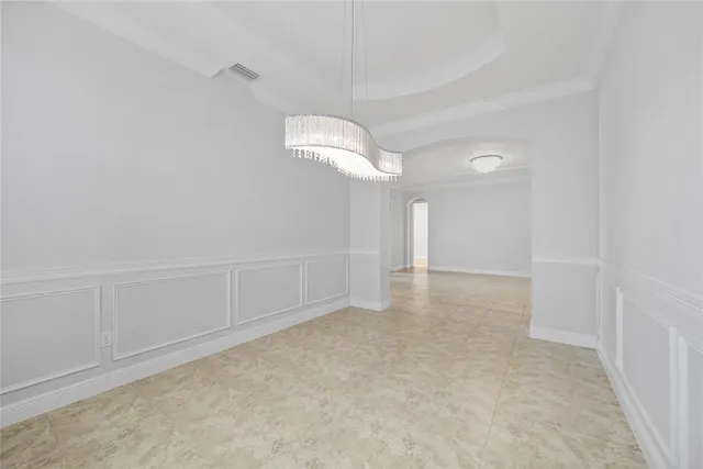 an empty room with a windows and chandelier