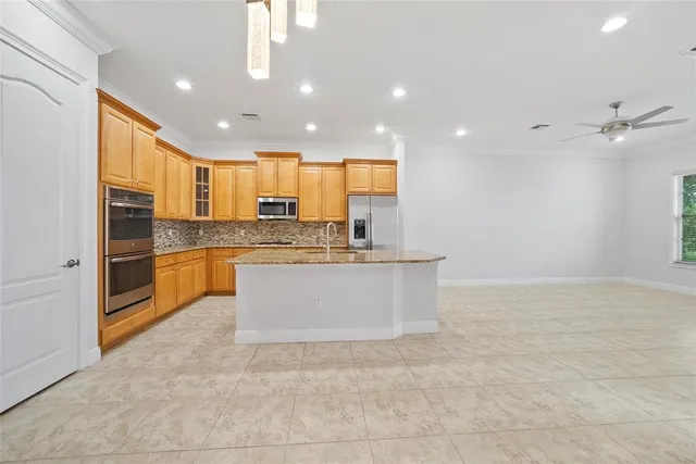 a large kitchen with stainless steel appliances granite countertop a sink and cabinets