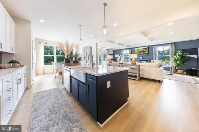 a large kitchen with kitchen island a large counter top a sink a stove and a window