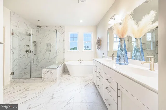 a spacious bathroom with a double vanity sink toilet mirror and bathtub