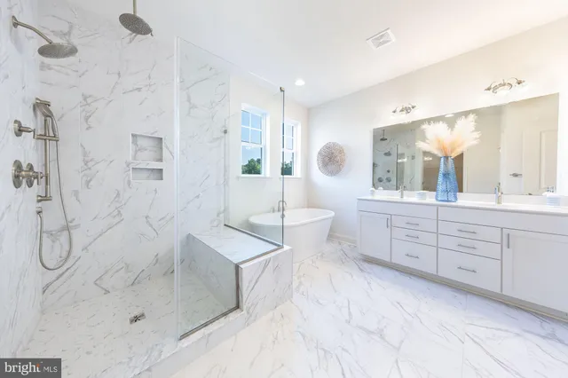 a spacious bathroom with a double vanity sink toilet mirror and bathtub