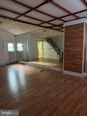 a view of an empty room with wooden floor